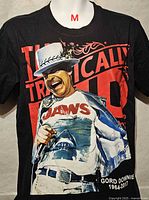 Front of black T-shirt showing The Tragically Hip red text, image of Gord Downie in Jaws shirt, size indicator M