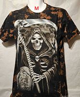 Front view of t-shirt showing tie-dye pattern and full Grim Reaper graphic with scythe and tombstone text