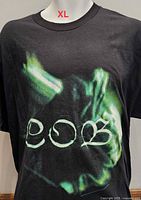 Front of black Children of Bodom T-shirt showing green abstract design and COB logo, size XL noted