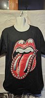 Front view of black T-shirt with Rolling Stones lips and tongue graphic