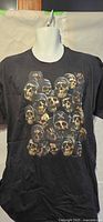 Front view of black XL T-shirt with skull helmet graphic