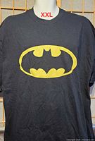 Front view of black Batman logo T-shirt showing size tag area