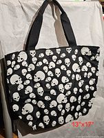 Front of tote bag showing skull print and handles