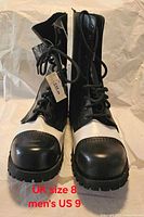 Front view of the pair of boots showing white toe caps, laces, and size note