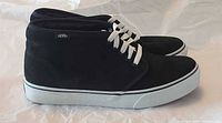 Left side view of both black Vans Chukka Boot sneakers showing suede uppers and white rubber soles