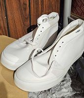 Side view of white Vans chukka boots on packing paper