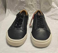 Front view of both shoes showing toes, laces, outsole, and attached tag