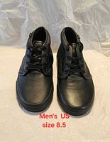 Front view of black leather Vans shoes showing toe boxes and lacing