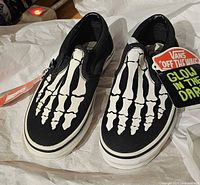 Top view of both shoes showing skeleton graphic and tags