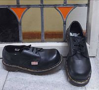 Pair of Dr. Martens 2226 black steel-toe shoes front and side view