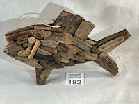 Front view of driftwood fish sculpture showing texture and rope hanger