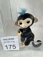 Front view of Fingerlings "Finn" toy gripping display stand