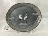 Front view of oval dish showing crane artwork and crackle glaze