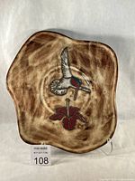 Front view of irregular stoneware platter showing hummingbird design