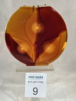 Full front view of round coloured glass vase showing three almond motifs