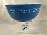 Side view of blue Pyrex Snowflake Garland 403 bowl on stand