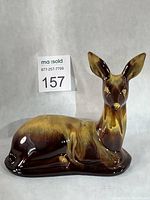 Front view of reclining deer figurine showing overall form and glaze