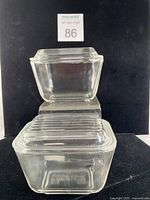 Two stacked clear glass Pyrex refrigerator dishes with lids