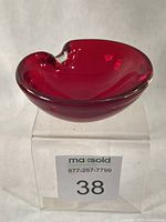 Oblique view of ruby red heart-shaped glass bowl showing overall form and clear rim