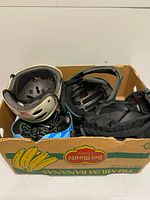 Box containing three helmets and protective pads