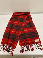 Full view of scarf laid flat showing tartan pattern and fringe