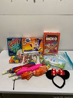 Group shot of all items including boxed games, bags of toys, umbrellas, counting bears set, headband