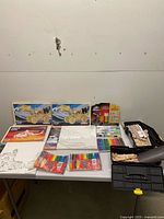 Full lot on table showing wooden model kits, canvas sets, markers, clay, bead kit and toolboxes of supplies