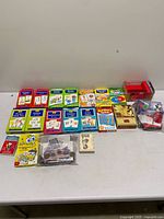 Full lot overview on table showing all boxed card sets and bag of play money