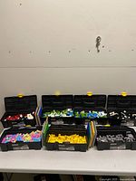 Seven toolboxes with colour-sorted bricks and stack of baseplates