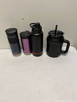 Group shot of all four drink containers upright on table