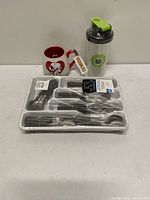 All three items together: sealed flatware set, Snoopy mug, sealed shaker bottle