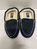 Top view of both slippers showing black suede, contrast stitching, faux shearling lining