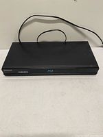 Top and front view of Samsung BD-P1600 player showing power cord