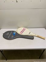 Two racquets with covers on table