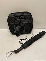 Front view of folded rolling duffle bag with umbrella