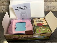Open box showing pink device and card pack