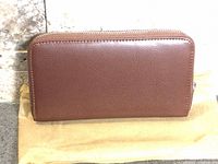 Front view of brown zip-around wallet on dust cover