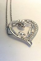 Close-up of heart pendant showing inscription, bear silhouettes and pavé stones