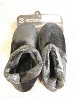 Top view showing black faux-fur slippers with tag attached