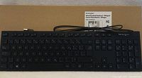 Keyboard atop original box showing full key layout and attached USB cable
