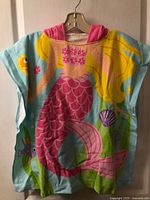 Front view of hooded towel showing mermaid graphic and hood