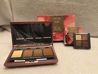 Open full-size eyeshadow palette, travel palette, and outer packaging visible