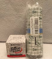 Treatonic numbing cream box beside sealed 6 in × 10 yd tattoo aftercare bandage roll