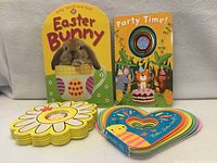 All four board books displayed: arch-shaped Easter Bunny, Party Time! with spinner, daisy-shaped Bella’s First Words, heart-shaped Flutter, Flutter Little Lovebug