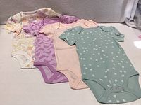 Four bodysuits laid flat showing all prints