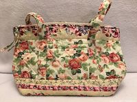 Front view showing quilted floral exterior and handles