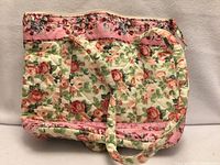 front view of quilted floral tote bag showing rose pattern and straps