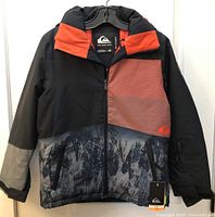 Front view of Quiksilver youth winter coat showing color scheme, front zipper, tags