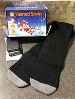 Pair of black heated socks, battery pack and retail box