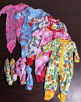 All five onesies with five hair ties displayed on table